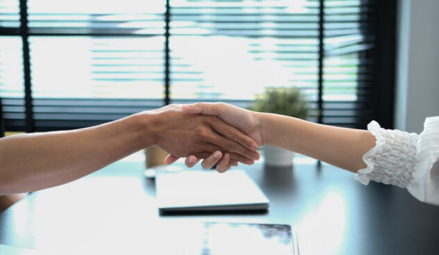 Businesspeople shaking hands after closing deal or successful negotiations at meeting